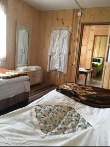 a bedroom with two beds in a room with wooden walls at Guesthouse Nakudurta in Dart'lo