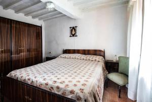 1 dormitorio con 1 cama y 1 silla en Da Pietro, en Bagni di Lucca