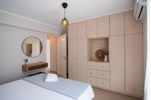 a bedroom with a white bed and a mirror at La Strada Apartment in Lefkada