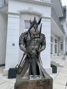 une statue d'un homme tenant deux épées dans l'établissement APARTAMENTY POSEJDON, à Świnoujście