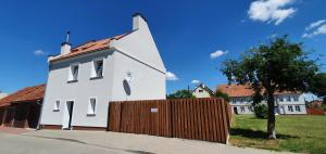 a white house with a wooden fence in front of it at Dom w mieście Reszel in Reszel