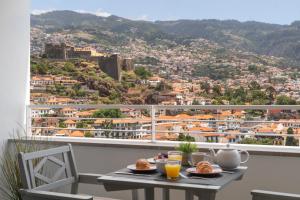 - une table avec de la nourriture sur un balcon avec vue dans l'établissement Jasmineiro I by An Island Apart, à Funchal