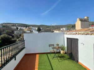 niewielki balkon ze stołem i krzesłami. w obiekcie Vivienda rural “Los Nacimientos” w mieście Alhama de Granada