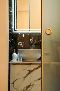 a bathroom with a sink and a mirror at Polymnia Luxury Apartments Argostoli in Argostoli