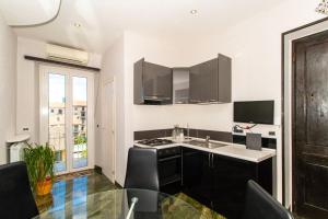 a kitchen with black cabinets and a counter top at Borgo San Paolo Stylish Apt with Jacuzzi in Turin