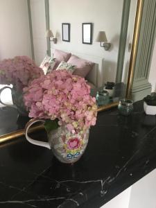 un vase rempli de fleurs roses sur une table dans l'établissement un dimanche chez Julie chambre Léontine, à Parthenay