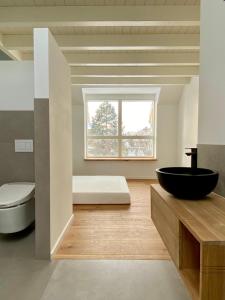ein Bad mit einem schwarzen Waschbecken und einem Fenster in der Unterkunft “STADT-LAND-SCHEUNE” - luxuriös in alten Gemäuern in Braunschweig