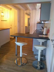 a kitchen with a counter and two stools at Oase der Geborgenheit in Venningen