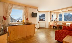 um quarto com uma cozinha e uma sala de estar com um sofá em Apartments Antines em Selva di Val Gardena