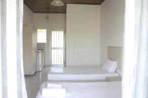 um quarto com paredes brancas e almofadas brancas em MARIA STUDIOS LAGANAS em Laganas