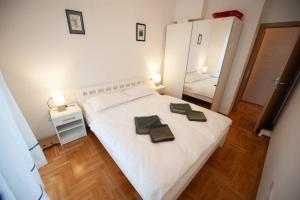 um quarto com uma cama branca com duas toalhas em SANSSOUCI Apartment em Trebinje