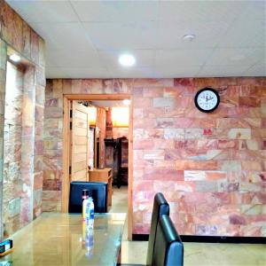 Habitación con pared de piedra y reloj en la pared en Hotel Vista Inn DHA, en Rawalpindi