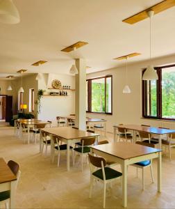 jadalnia ze stołami, krzesłami i oknami w obiekcie Dimore Montane w mieście Roccamorice
