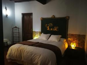 a bedroom with a large bed with a headboard at El Jardin del Conde in Puerto de Béjar
