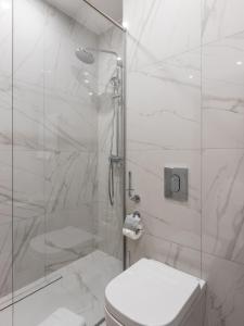 a white bathroom with a shower and a toilet at AZIMUT Hotel Tula in Tula