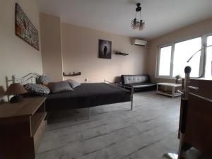 ein Schlafzimmer mit einem Bett und ein Wohnzimmer mit einem Sofa in der Unterkunft Lefterov's Guests Suite in Warna