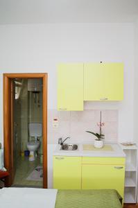 a kitchen with yellow cabinets and a sink and a toilet at Mostar Orient in Mostar