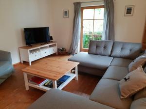 uma sala de estar com um sofá e uma televisão em Martina's place em Rottenbuch