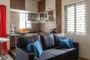 a living room with a couch and a kitchen at Cosy Penthouse with High speed wifi-UPS near WTC-IISC in Bangalore