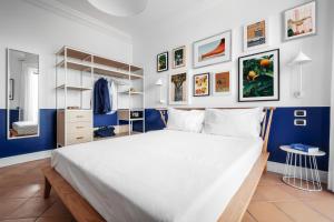 索倫托的住宿－Sorrento & Else - Deluxe Apartments，卧室配有白色大床和蓝色的墙壁
