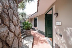 a house with a green door and a stone wall at Sorrento & Else - Deluxe Apartments in Sorrento