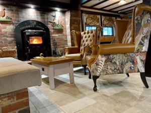 a living room with chairs and a fireplace at The Cedar Country Hotel in Bellway