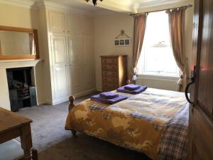 a bedroom with a bed with purple towels on it at Ceilidh Cottage in York