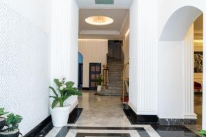 a hallway with white walls and a potted plant at Hotel Majestic in Casablanca