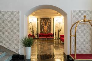 a living room with red furniture and an archway at Hotel Majestic in Casablanca
