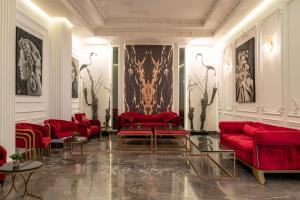 a living room with red couches and tables at Hotel Majestic in Casablanca