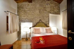 a bedroom with a white bed and white walls at hotel dei consoli in Gubbio