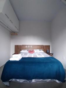 um quarto com uma cama com um cobertor azul em Aconchego Premium em Angra dos Reis mais 12 fotografias