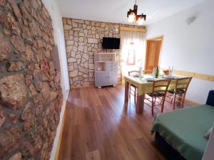 a living room with a table and a stone wall at Villa Mira Garica in Garica