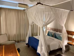 Säng eller sängar i ett rum på Sundown Guest House Maputo