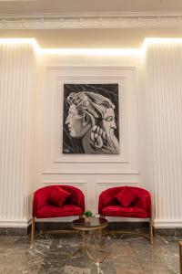 two red benches in a room with a painting on the wall at Hotel Majestic in Casablanca