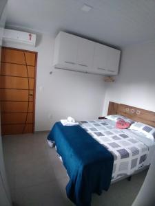 um pequeno quarto com uma cama com um cobertor azul em Aconchego Premium em Angra dos Reis