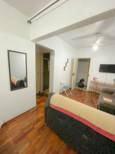 een slaapkamer met een groot bed en een woonkamer bij Estúdio/Apartamento praia de São Vicente in São Vicente