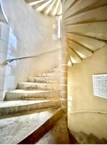 a staircase in a building with a sign on the wall at Logis Saint-Flaceau in Le Mans