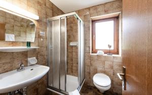 un bagno con un lavandino e una doccia di Raschötzhof a Funes