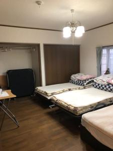 um quarto com duas camas e uma mesa em Youyousanso Modern B em Tsu