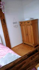 a bedroom with a bed and a wooden cabinet at Landhaus im Hunsrück in Henau