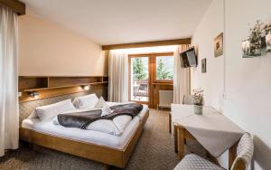 una camera d'albergo con un letto e un tavolo di Raschötzhof a Funes