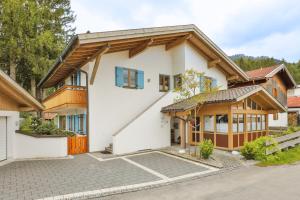 ein großes weißes Haus mit Holzdach in der Unterkunft Fewo Ammertal in Oberammergau