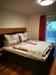 a bedroom with a large bed with pillows and a window at Apart Pichler in Schlitters