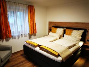 ein großes Bett in einem Zimmer mit Fenster in der Unterkunft Apart Pichler in Schlitters