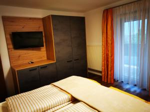a bedroom with a cabinet with a television in it at Apart Pichler in Schlitters