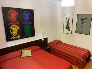 a bedroom with a red bed and a stool at Hotel Stazione del Sole in Albenga
