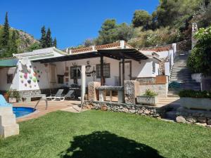 einen Hinterhof mit einem Pool und einem Haus in der Unterkunft CASA GASPAR, alojamiento rural con vistas al mar en paraje natural in Granada