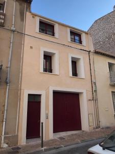 un bâtiment avec trois portes et fenêtres de garage dans l'établissement Le "Duo Sètois", à Sète