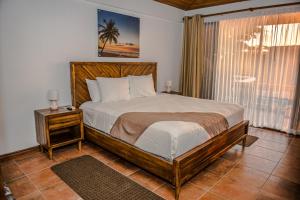 a bedroom with a bed and a lamp at Jaco Laguna Resort & Beach Club in Jacó